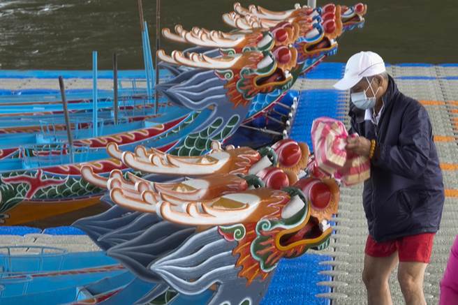 工作人员分别向基隆河撒经衣、烧银纸，并逐艘向龙舟献金纸。（黄子明摄）