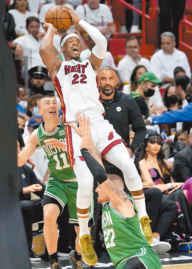 热火前锋吉米巴特勒在塞尔提克球员的防守下，失去重心仍想尝试投篮。（美联社）