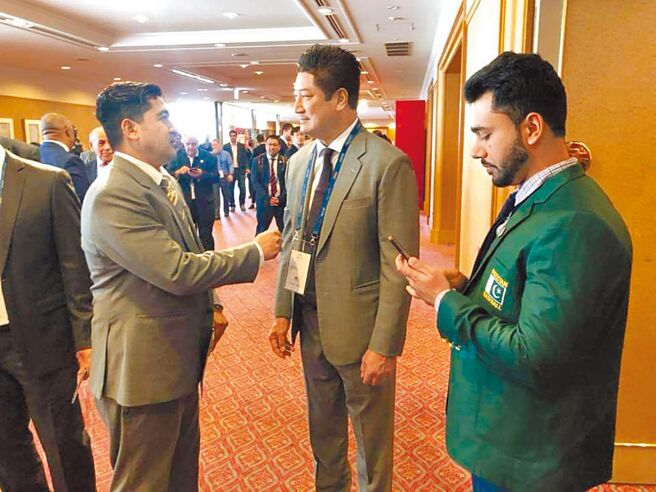 中华棒协理事长辜仲谅（中）在2019年WBSC会员大会与巴基斯坦棒协理事长交换意见。（中华棒协脸书粉丝团翻摄）